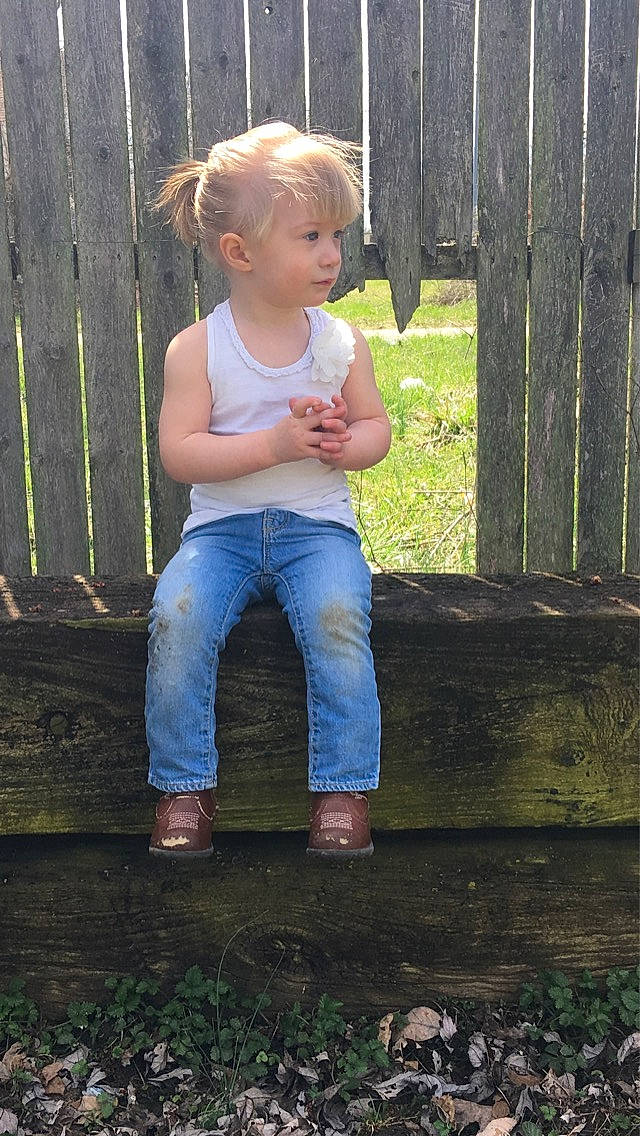 Nevaeh is registered to the contest to win money with this photo: blond, child, grass, jeans, person, sitting, standing, toddler, tree, wood