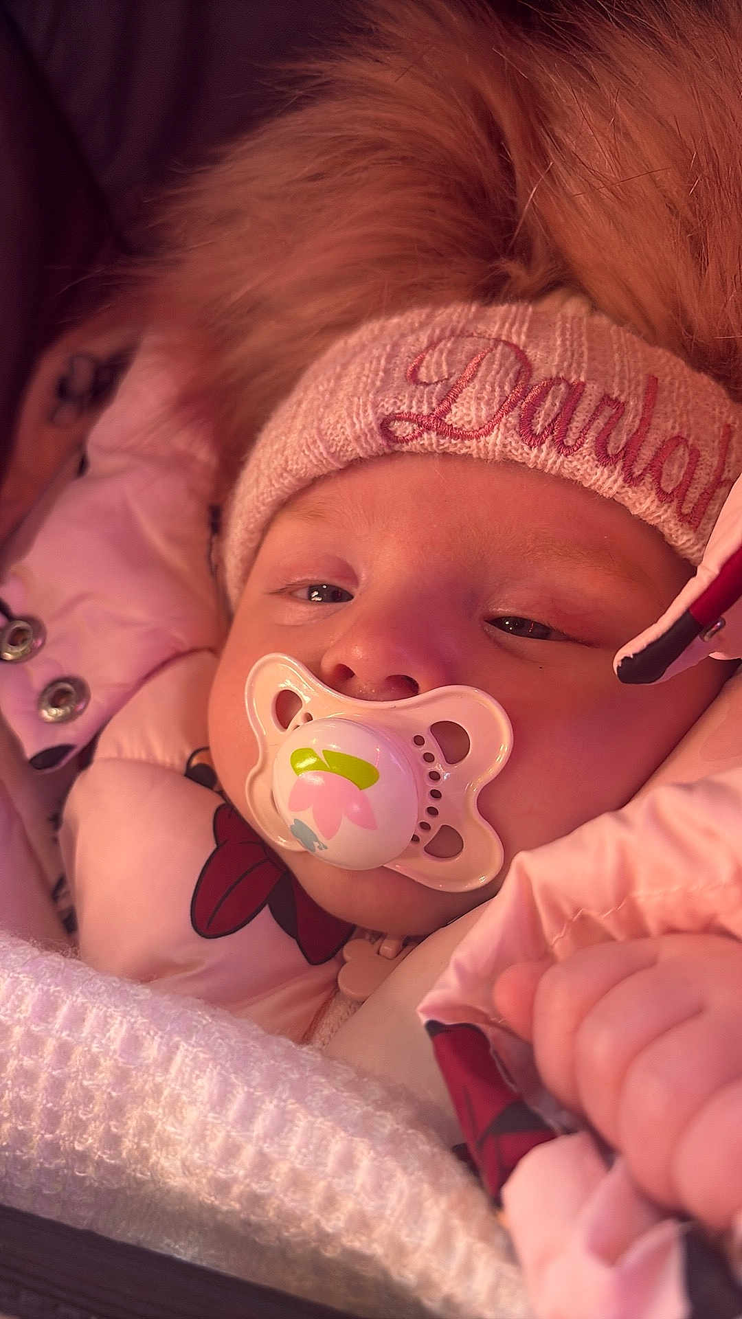 Darlah is registered to the contest to win money with this photo: baby, pacifier, hat, pink_jacket, blanket, sleepy, cozy, child, face, hand, winter_clothing, fur_trim, closeup, infant, cute, warm, soft, portrait, snug, young_child