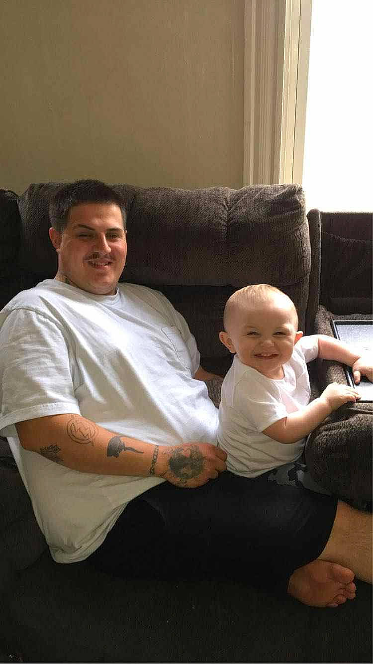 Emmett joined the competition — help win amazing prizes! abdomen, baby, child, comfort, couch, elbow, event, flooring, fun, head, joy, lap, living_room, person, room, sitting, smile, t_shirt, thigh, toddler