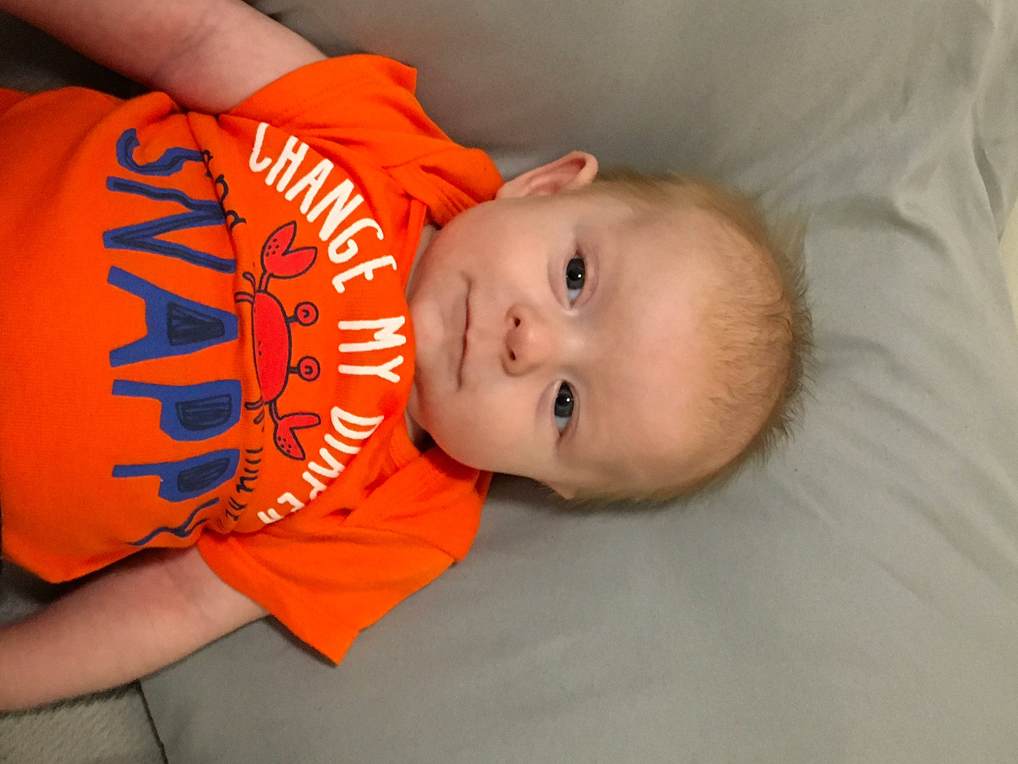 Loki joined the competition — help win amazing prizes! baby, baby_toddler_clothing, cheek, child, comfort, elbow, fun, happy, human_leg, neck, orange, person, room, sitting, sleeve, t_shirt, thigh, toddler, wrist