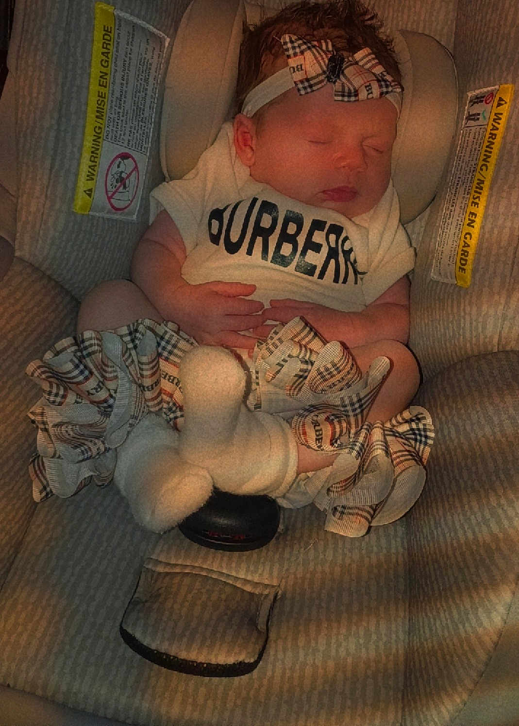 Evalyn joined the competition — help win amazing prizes! baby, infant, car_seat, sleeping, headband, bow, plaid, ruffles, socks, tiny_hands, plush_toy, warning_label, shirt, brand_logo, closeup, portrait, indoors, cute, newborn, seat_buckle