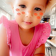 Bella joined the competition — help win amazing prizes! toddler, child, pink_dress, face_filter, lipstick_marks, smiling, curly_hair, indoor, table, chair, casual, portrait, cute, baby, person, young_child, playful, closeup, happy, daylight