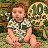 baby, infant, child, portrait, sitting, curious, face, eyes, smiling, dinosaur, stuffed_animal, plush_toy, milestone, ten_months, wooden_sign, jungle_theme, tropical_leaves, greenery, onesie, indoor