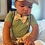 toddler, child, baby, boy, hat, bow_tie, suspenders, shirt, shoes, bed, indoor, hands, face, curious, clothing, portrait, person, cute, fashion, furniture
