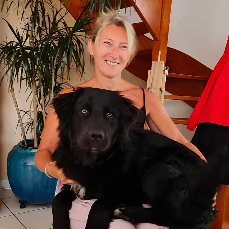 Camerone participe au concours pour gagner de l'argent avec cette photo : black_dog, blonde_hair, casual_clothing, dog, friendly, happy, home, indoor, large_dog, living_room, pet, plant, portrait, pot, relaxed, sitting, smiling, tile_floor, woman, wooden_stairs