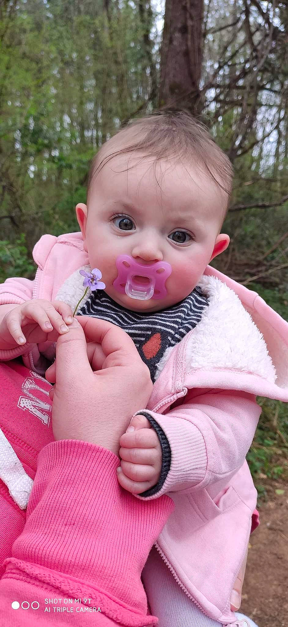 énola participe au concours pour gagner de l'argent avec cette photo : baby, baby_toddler_clothing, cheek, child, eyelash, face, finger, gesture, grass, hand, happy, iris, lip, nose, outerwear, person, pink, plant, skin, toddler