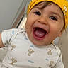 baby, cheerful, child, closeup, clothing, cute, face, happy, headwear, hot_air_balloon_pattern, indoor, infant, laughing, onesie, person, playful, portrait, smiling, yellow_bandana, young_child