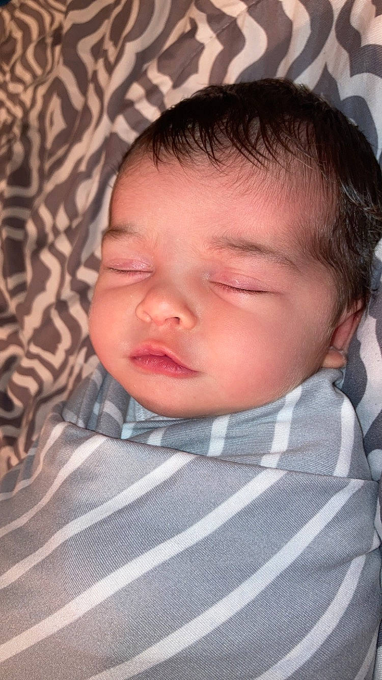 Beverly is registered to the contest to win money with this photo: baby, baby_toddler_clothing, bedtime, cheek, child, collar, comfort, dress_shirt, ear, eye, eyebrow, eyelash, linens, lip, mouth, nose, pattern, person, skin, sleeve