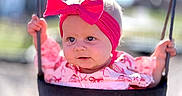 Huntleigh joined the competition — help win amazing prizes! baby, child, swing, playground, headband, pink_bow, outdoor, sunny, daylight, face, clothing, hands, metal, seat, person, infant, cute, holding, fun, expression