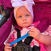 Huntleigh joined the competition — help win amazing prizes! baby, child, blue_eyes, white_bow, stroller, magenta, pink_dress, safety_harness, spoon, curious, cute, outdoor, infant, portrait, hand, face, headband, seat, fabric, person