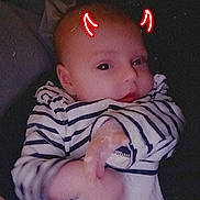 Céleste participe au concours pour gagner de l'argent avec cette photo : baby, infant, striped_clothing, lying_down, face, hand, red_horns, doodle, glow, cute, child, portrait, indoors, soft_light, expression, person, young_child, casual, head, skin