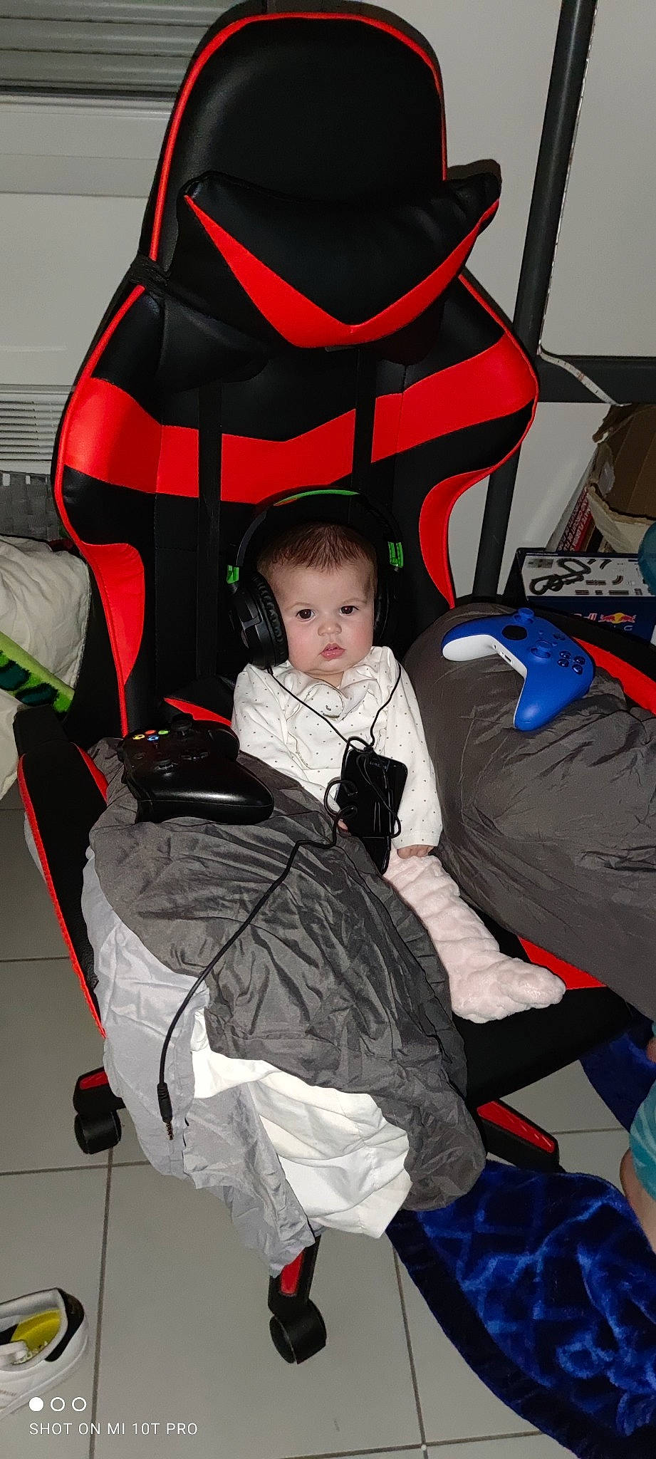 Maïna a rejoint le concours — aidez-le/la à gagner de superbes lots ! baby, baby_carriage, baby_products, baby_toddler_clothing, bag, black, chair, child, comfort, event, fun, lap, outerwear, person, personal_protective_equipment, photograph, product, red, sitting, toddler