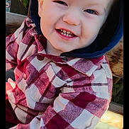 Liam Andrew is registered to the contest to win money with this photo: toddler, child, smiling, plaid_jacket, hood, outdoor, bench, wood, happy, face, person, casual_clothing, daylight, cute, portrait, young_child, sitting, playful, light, nature