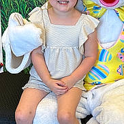 Gracie joined the competition — help win amazing prizes! baby, child, clothing, couch, dress, face, female, footwear, furniture, girl, head, nature, outdoors, person, photography, portrait, sandal, shoe, shorts, sneaker