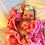 baby, blanket, pink, bow, headband, smile, face, hand, bed, white_bedding, soft_texture, cute, infant, child, cozy, wrapped, sleeping_area, warm, happy, portrait