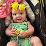 Delia is registered to the contest to win money with this photo: baby, child, yellow_bow, car_seat, toy, blanket, green_outfit, smiling, cute, infant, indoor, happy, person, seatbelt, soft_texture, plush, headband, comfort, closeup, portrait