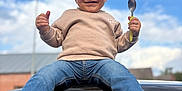 Lylio a rejoint le concours — aidez-le/la à gagner de superbes lots ! child, toddler, smiling, blue_sky, clouds, car_roof, jeans, socks, sweater, spoon, outdoor, happy, person, casual_clothing, daylight, playful, young_child, portrait, fun, sky