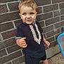 Lylio participe au concours pour gagner de l'argent avec cette photo : child, barefoot, blue_eyes, brick_wall, clothing, embroidery, expression, face, footwear_none, funny_expression, outdoor, pebble_floor, person, portrait, shorts, standing, traditional_clothing, young_child, youth, smile