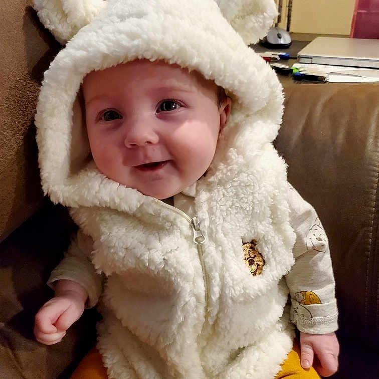 Everleigh is registered to the contest to win money with this photo: baby, blanket, bonnet, clothing, coat, computer, electronics, face, happy, hat, head, hood, hoodie, jacket, knitwear, laptop, pc, person, photography, portrait