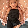 Neylana participe au concours pour gagner de l'argent avec cette photo : baby, infant, child, headband, pink_bow, black_romper, blanket, sun_pattern, couch, gray_couch, lying_down, curious_expression, indoors, soft_lighting, skin, face, hands, feet, person, portrait