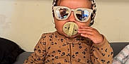 Nalani joined the competition — help win amazing prizes! baby, child, pacifier, sunglasses, headband, leopard_print, pajamas, bed, blanket, indoor, person, cute, fashion, reflection, cozy, sitting, infant, portrait, accessory, comfort