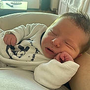 Charlie a rejoint le concours — aidez-le/la à gagner de superbes lots ! baby, newborn, sleeping, face, hand, fist, mickey_print, onesie, blanket, cushion, indoor, portrait, soft_lighting, hair, closeup, peaceful, parent_arm, nursery, cozy, skin