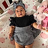 baby, child, infant, portrait, lying_down, crib, crib_mattress, headband, dress, black_and_white, patterned_clothing, socks, plush_toy, elephant, pink, stars, clouds, indoors, smiling, fashion