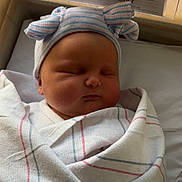 Serenity is registered to the contest to win money with this photo: newborn, baby, sleeping, swaddled, hospital, blanket, hat, bassinet, infant, cute, peaceful, face, portrait, child, bed, cozy, resting, striped, wearing, indoors