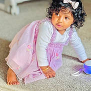 Liya is registered to the contest to win money with this photo: baby, barefoot, blue_light, bow, bracelet, carpet, child, crawling, curious, curly_hair, cute, embroidery, floor, indoors, lavender_dress, portrait, soft_light, toddler, toy, young_child