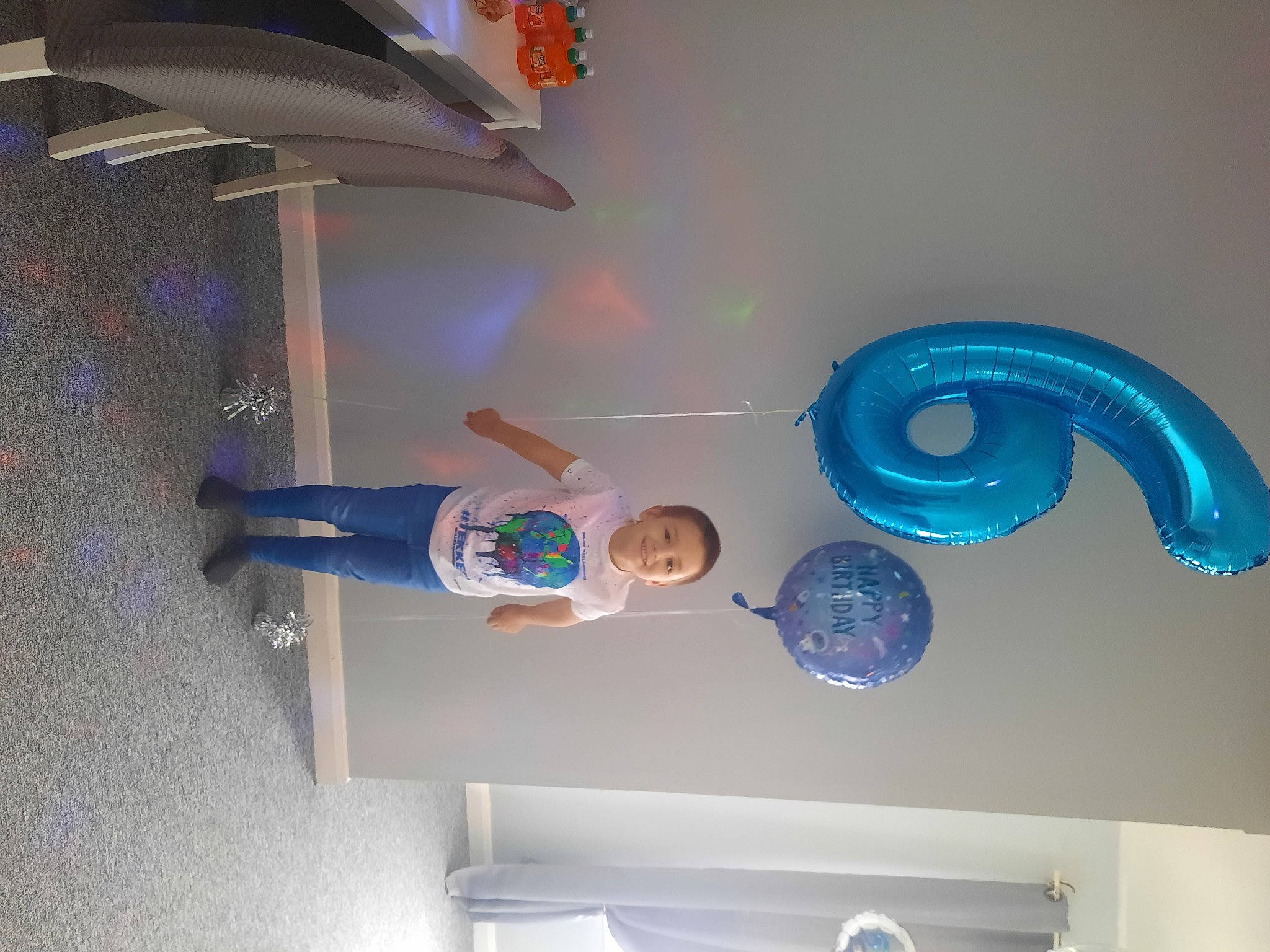Eddie is registered to the contest to win money with this photo: arch, art, balloon, blue, ceiling, circle, electric_blue, font, fun, graphic_design, graphics, joy, machine, party_supply, person, plaster, room, shelf, smile, space