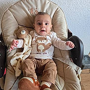 Dani a rejoint le concours — aidez-le/la à gagner de superbes lots ! baby, infant, child, plush_toy, blanket, baby_chair, cushion, cute, clothing, footwear, indoors, wood_floor, wall, expression, face, person, smile, sitting, comfort, toddler