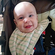 Célestin participe au concours pour gagner de l'argent avec cette photo : baby, child, smiling, stroller, bib, clothing, face, happy, infant, seatbelt, portrait, head, cute, person, indoor, denim, striped, fabric, closeup, seat