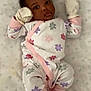 baby, infant, onesie, mittens, socks, lying_down, bed, mattress, pattern, floral, cute, child, newborn, sleepwear, pink, white, purple, red, face, portrait