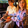 Indica joined the competition — help win amazing prizes! child, children, cat, gaming_controller, plush_toy, pajamas, indoor, computer, chair, boy, girl, pet, playing, smiling, long_hair, sweatpants, technology, relaxing, home, cute