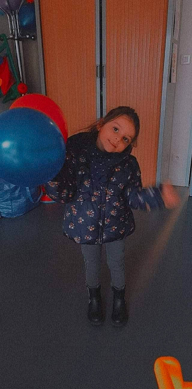 Giuliana participe au concours pour gagner de l'argent avec cette photo : baby_toddler_clothing, balloon, boot, child, electric_blue, floor, flooring, fun, hairstyle, happy, human_body, human_leg, knee, party_supply, pattern, person, purple, smile, sock, standing
