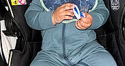 Drayden is registered to the contest to win money with this photo: baby, black_car_seat, blue_clothing, car_seat, child, cute, expression, face, hands, headwear, hooded_outfit, indoor, infant, pacifier, person, seatbelt, sitting, socks, warning_label, young_child