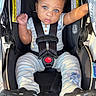baby, child, car_seat, blue_eyes, onesie, striped_clothing, stitch_character, footwear, black_shoes, seatbelt, infant, cute, drool, curious, indoor, close_up, baby_clothing, safety_harness, person, portrait