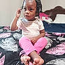 Mya joined the competition — help win amazing prizes! child, toddler, braided_hair, beads, pink_pants, white_shirt, bed, blanket, feather_pattern, indoor, furniture, foot, hand, person, portrait, young_child, curious, sitting, expression, room
