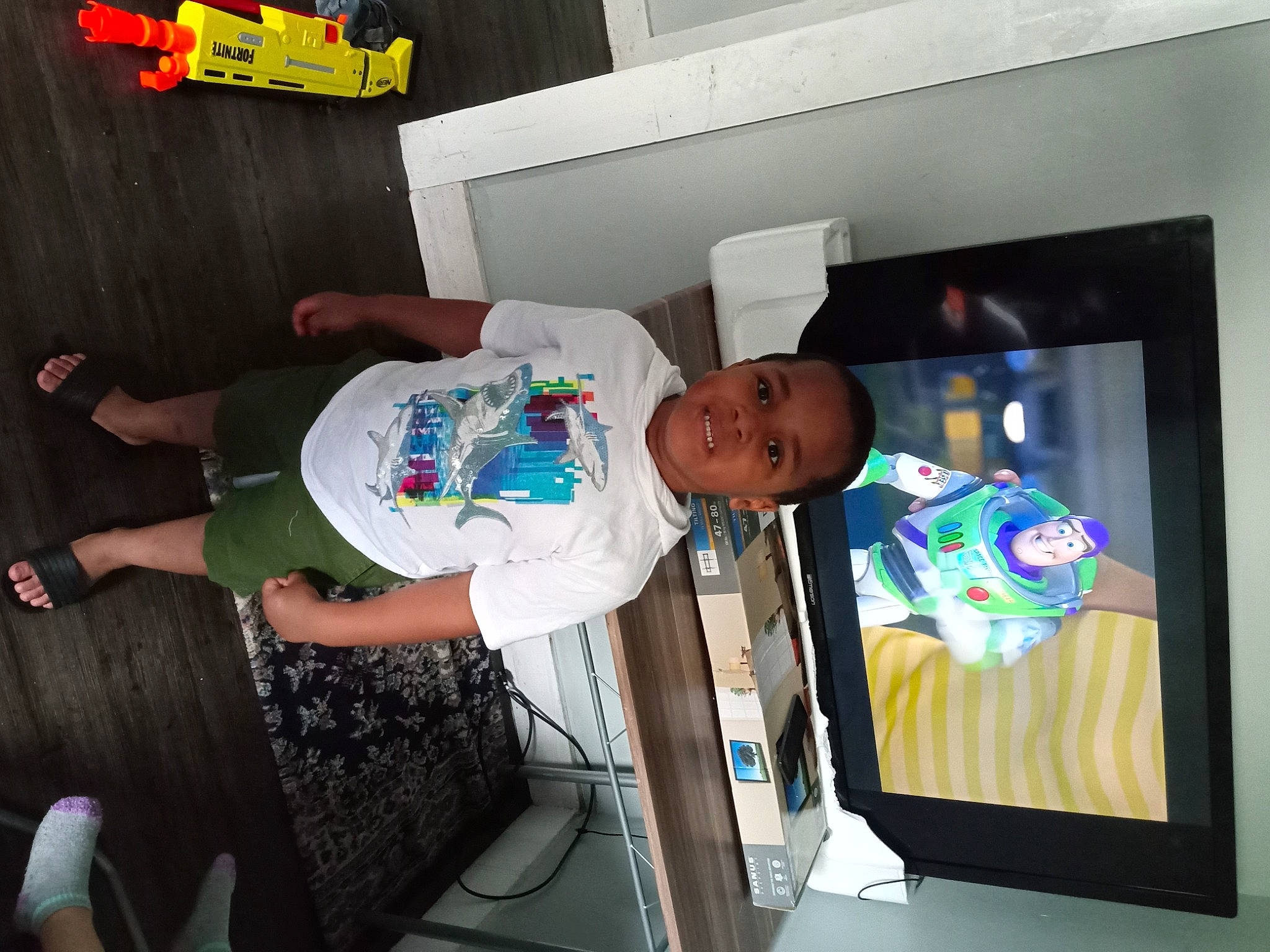 Jahmear is registered to the contest to win money with this photo: advertising, baby, child, comfort, display_device, elbow, event, fun, hat, human_leg, joy, person, room, smile, t_shirt, television_set, thigh, toddler