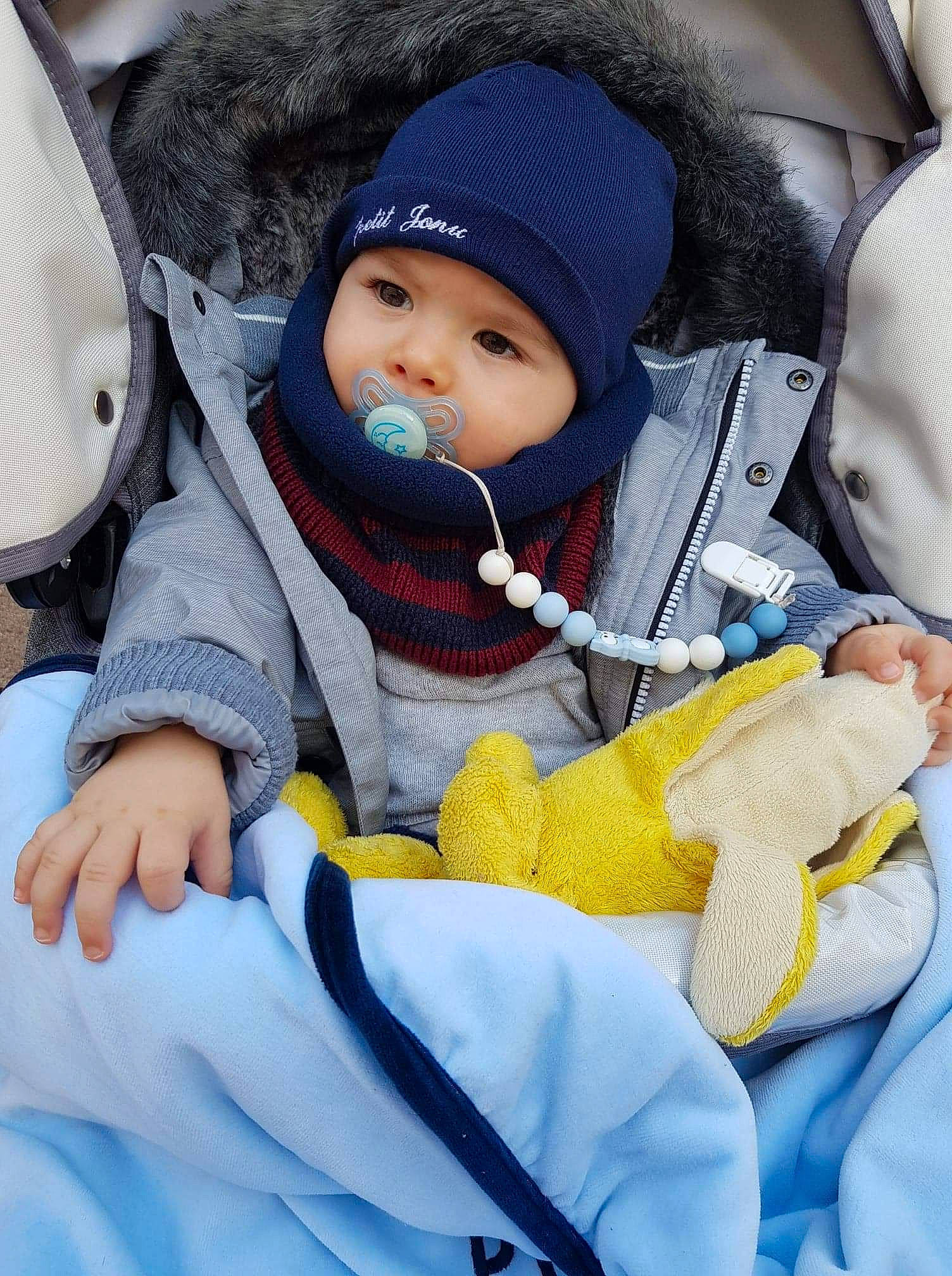 Luis Junior a rejoint le concours — aidez-le/la à gagner de superbes lots ! baby, baby_carriage, baby_in_car_seat, baby_products, baby_safety, baby_sleeping, baby_toddler_clothing, beanie, blue, cap, car_seat, cheek, child, comfort, headwear, person, product, seat_belt, sitting, skin