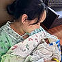 Milan is registered to the contest to win money with this photo: newborn, baby, mother, hospital, blanket, footprints, woman, infant, swaddled, love, care, hair_clip, hospital_gown, patient, holding, face, indoor, tender, family, healthcare