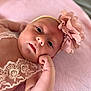 Aimée participe au concours pour gagner de l'argent avec cette photo : baby, infant, face, headband, flower, pink, blanket, lace, clothing, skin, portrait, cute, young, child, resting, hand, expression, soft, indoors, newborn