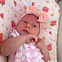 baby, infant, child, headband, bow, pink, dress, floral_pattern, blanket, strawberry_pattern, cute, lying_down, hands, face, skin, indoors, soft_texture, closeup, portrait, newborn