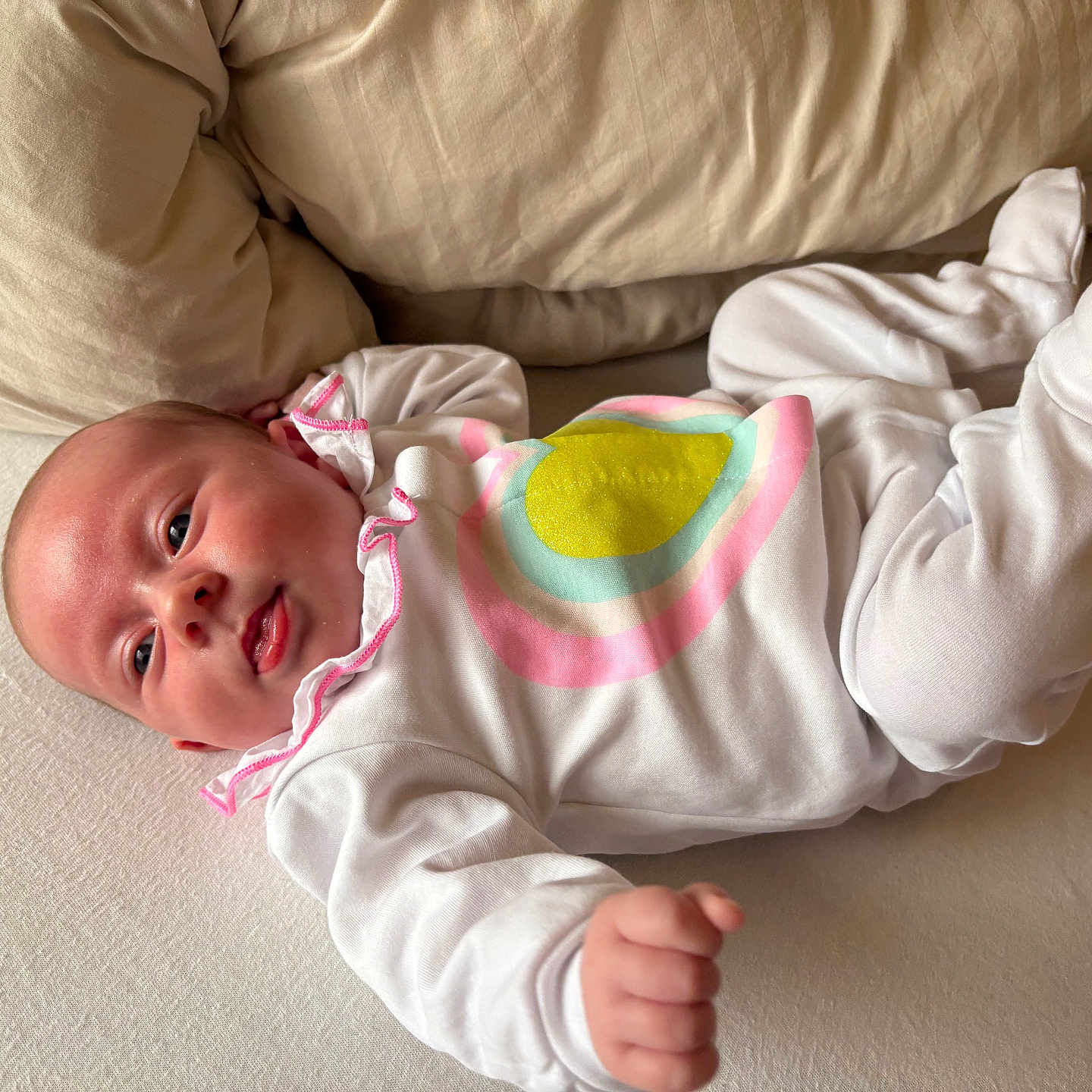 Aimée a rejoint le concours — aidez-le/la à gagner de superbes lots ! baby, bed, child, colorful_pattern, cute, expression, face, footed_pajamas, hand, head, indoors, infant, lying_down, newborn, person, pillow, portrait, skin, sleepwear, white_clothing