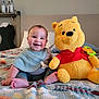 Sylas joined the competition — help win amazing prizes! baby, child, plush_toy, winnie_the_pooh, bed, blanket, smile, happy, indoor, toy, cute, person, seated, foot, clothing, head, face, home, room, comfort