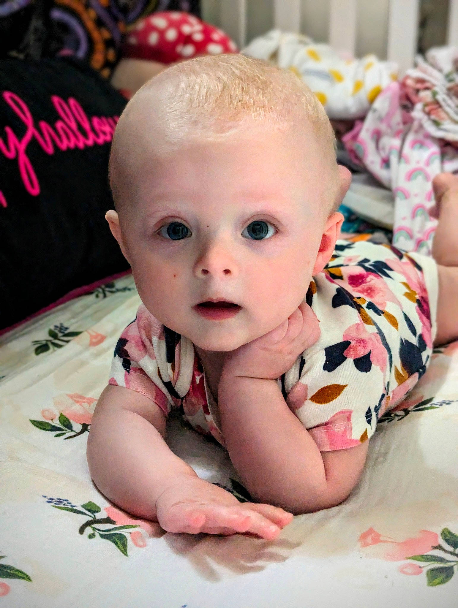 Xoey is registered to the contest to win money with this photo: baby, baby_toddler_clothing, carmine, cheek, child, comfort, flooring, fun, happy, iris, linens, person, pink, product, room, sitting, skin, sleeve, smile, surprise