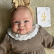 Victoria participe au concours pour gagner de l'argent avec cette photo : baby, infant, headband, bow, pouty_face, milestone_card, 4_months, carpet, soft_texture, clothing, neutral_colors, cute, portrait, child, young_baby, indoors, close_up, smiling_eyes, white_collar, lying_down