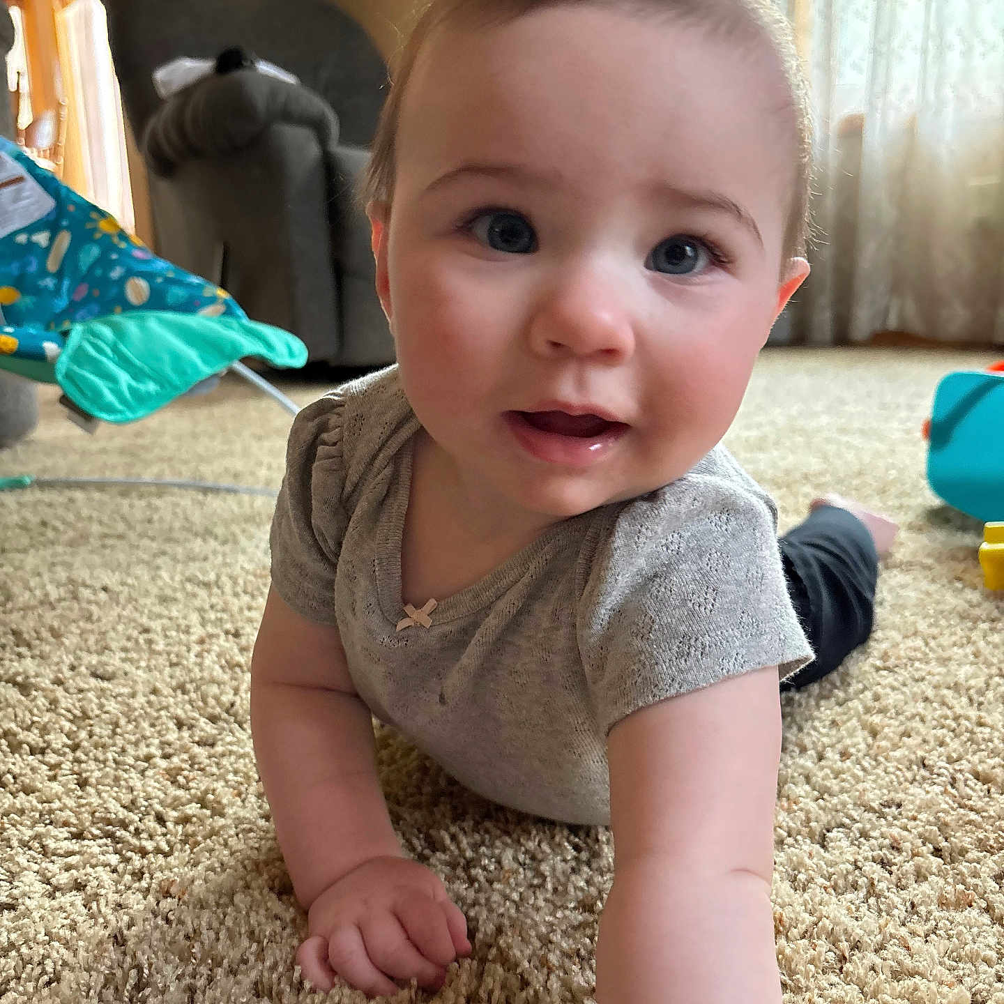 Miley is registered to the contest to win money with this photo: baby, child, carpet, crawling, indoor, living_room, person, face, hand, clothing, toy, curious, soft_lighting, furniture, window, curtain, floor, expression, home, infant