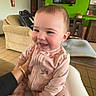 Miley joined the competition — help win amazing prizes! baby, smiling, pink_onesie, indoor, living_room, couch, baby_car_seat, green_wall, television, person, happy, child, floor_tiles, furniture, hand, portrait, cute, animal_print, seated, infant