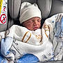 newborn, baby, blanket, car_seat, hat, sleeping, infant, child, cozy, soft, pattern, fabric, rest, seatbelt, safety, comfort, cute, peaceful, indoors, portrait